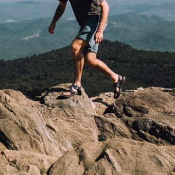 guy walking on rocks in mountains